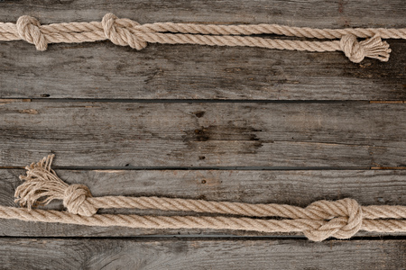 flat lay with marine ropes with knots on grunge wooden tabletop