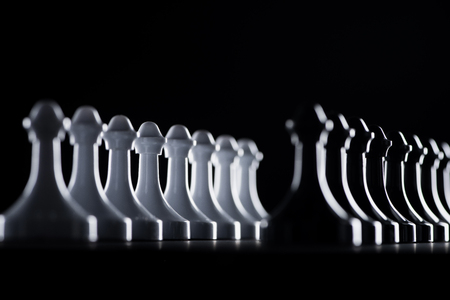 rows of white and black chess pawns isolated on black, business conceptの写真素材