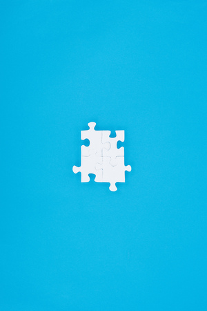 top view of assembled white puzzles isolated on blue, business conceptの写真素材