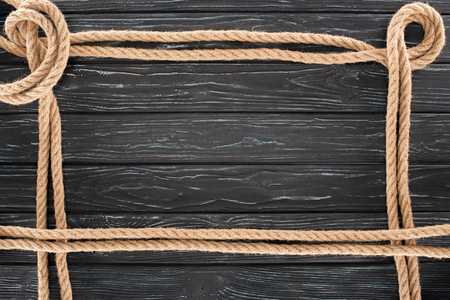 top view of brown ropes on dark wooden surfaceの写真素材