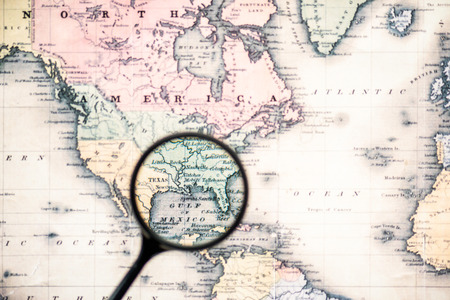top view of magnifying glass on world map over gulf mexicoの写真素材