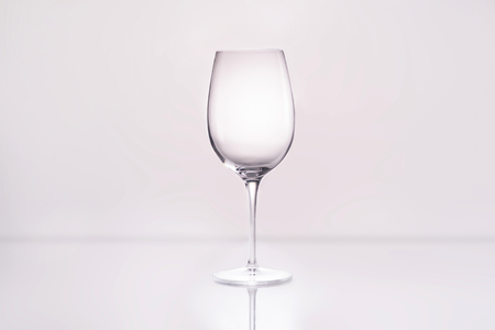 empty wineglass on reflective surface and on whiteの写真素材