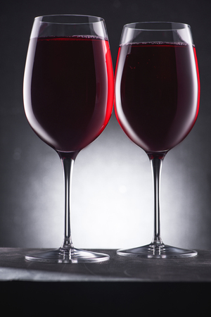 close-up shot of glasses full of delicious red wine on blackの写真素材