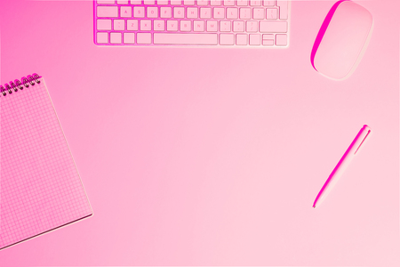 top view of computer keyboard and mouse, empty textbook and pen on pink table の写真素材