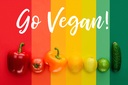 top view of ripe fruits and vegetables with words Go Vegan on colored surfaceの写真素材