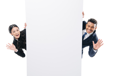 happy multiethnic businesspeople waving and holding empty board, isolated on white の写真素材