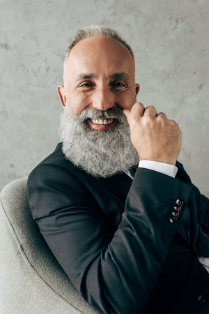 bearded successful senior handsome businessman on concrete wall backgroundの写真素材