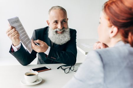 two adult business partners with contract in modern officeの写真素材