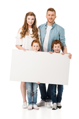 happy redhead family with two kids holding blank banner and smiling at camera isolated on white の写真素材