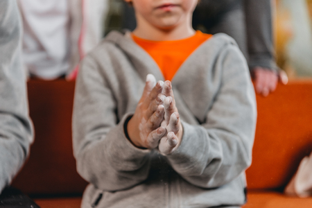 Cropped shot of a little boy in sportive attire applying talcum powder to palms of his handsの写真素材