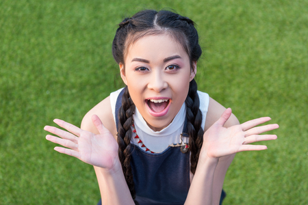 portrait of surprised asian girl gesturing with hands and looking at cameraの写真素材