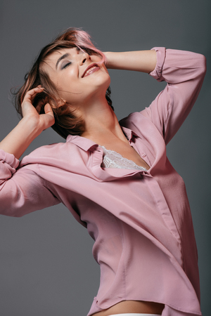 happy tender girl with closed eyes, isolated on greyの写真素材