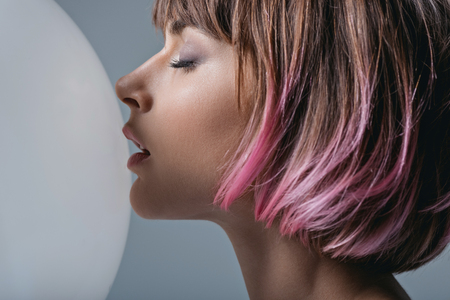 beautiful tender girl with pink hair and white balloon, isolated on greyの写真素材