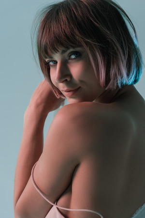 attractive sensual girl posing and looking at camera, isolated on blueの写真素材