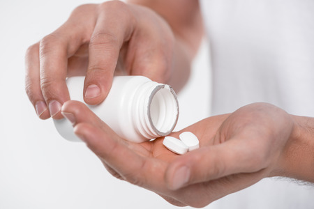 cropped view of man with white pills, isolated on whiteの写真素材