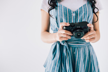 partial view of woman holding photo camera in hands isolated on greyの写真素材