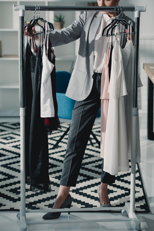 cropped shot of fashion designer choosing clothing from rackの写真素材