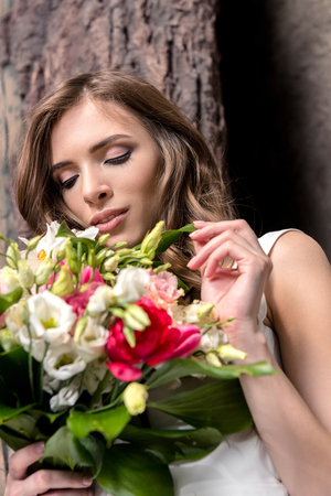 beautiful young woman holding wedding bouquetの写真素材