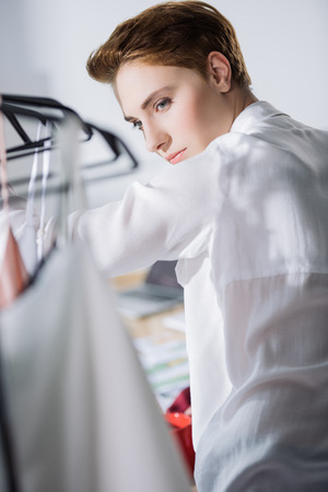 young fashion designer looking at dresses on rackの写真素材