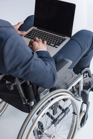cropped shot of disabled african american businessman typing on laptop in officeの写真素材
