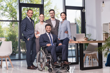 smiling multiethnic business team looking at camera in officeの写真素材