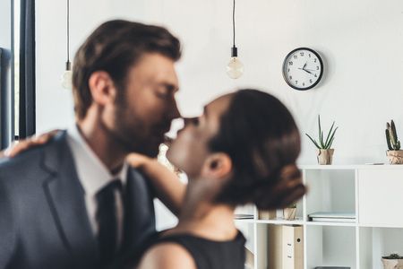 Young couple in formal wear leaning for a kissの写真素材