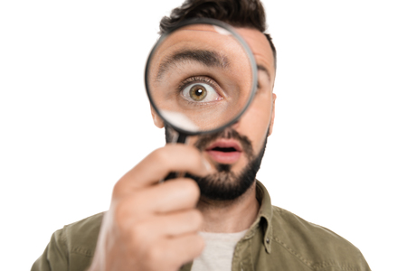 portrait of young man holding magnifying glass in hand isolated on whiteの写真素材