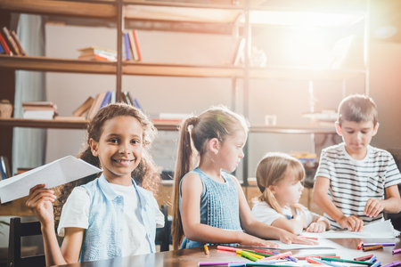 multiethnic group of children drawing pictures together at homeの写真素材
