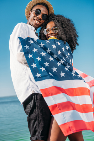 young happy african american couple with america flag hugging each otherの写真素材