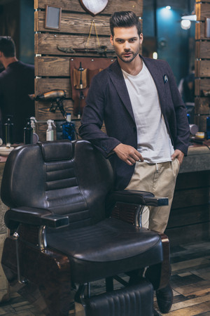 Portrait of handsome caucasian man with fashionable hairstyle at barber shopの写真素材