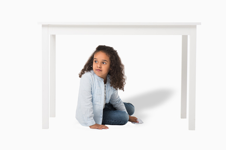 adorable african american girl sitting under table isolated on whiteの写真素材