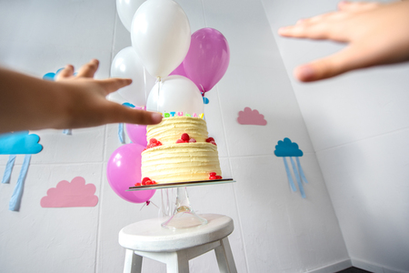 cropped shot of human hands reaching to delicious birthday cakeの写真素材