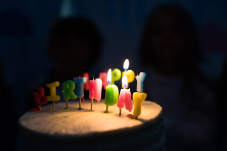 close-up view of delicious birthday cake with burning candles in dark room