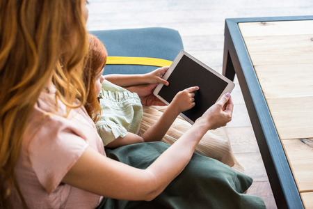 cropped shot of mother and daughter using digital tablet with blank screen