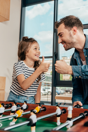 father and daughter celebrating win in table footballの写真素材