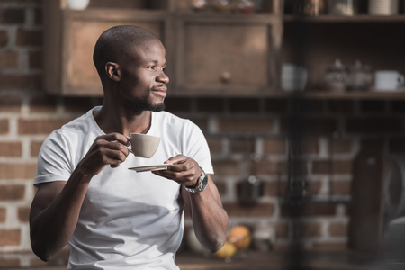 Handsome african american man having his morning coffee at homeの写真素材