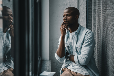 Portrait of young handsome african american man looking at windowの写真素材