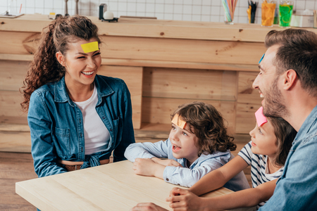 beautiful young family playing guess sticker in cafeの写真素材