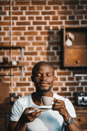 Handsome african american man having his morning coffee at homeの写真素材