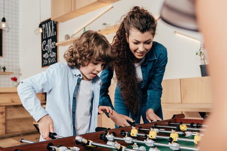 portait of happy mother and son playing table footbalの写真素材