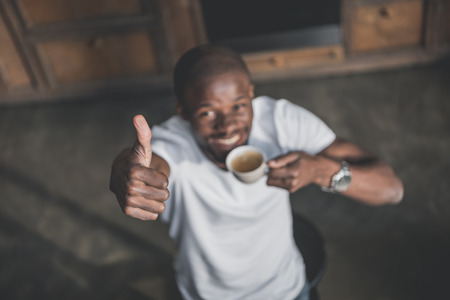 Handsome african american man having his morning coffee at homeの写真素材