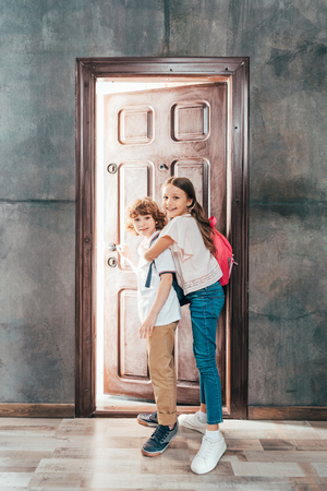 adorable kids walking through door, going to schoolの写真素材
