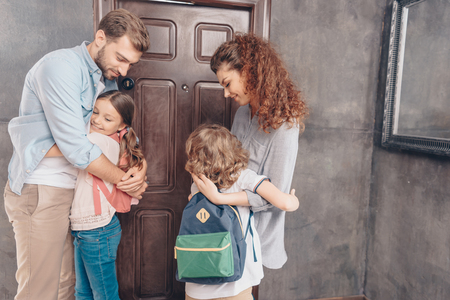 cute parents hug kids before schoolの写真素材