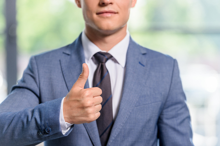 Young businessman showing thumb up gestureの写真素材