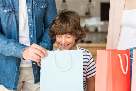 smiling happy boy with shopping bags and his parentsの写真素材