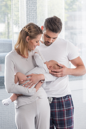 happy parents holding little baby at home の写真素材