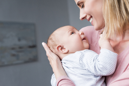attractive smiling mother holding her newborn son  の写真素材