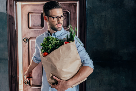attractive young man arrived from grocery storeの写真素材