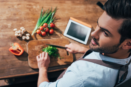 high angle view of handsome young man cooking with tabletの写真素材