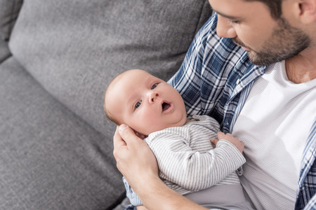 handsome father holding his cute newborn sonの写真素材
